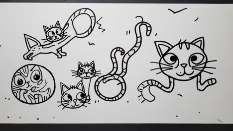hand drawing cartoon cats on paper