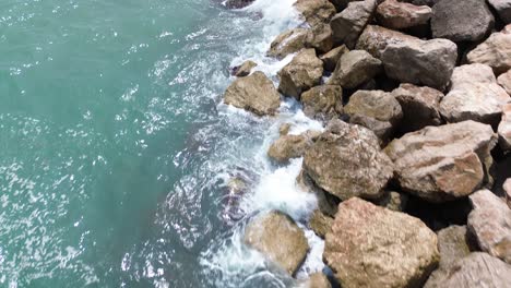 Toma-Aérea-De-Las-Rocas-En-La-Costa-Del-Mar-De-Sitges