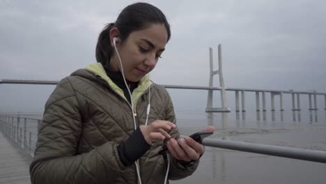 Una-Joven-Hindú-Sonriente-Escuchando-Música-Desde-Un-Smartphone