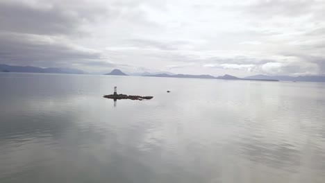 weite luftaufnahme des vanderbilt-riffs von vanderbilt-riff, von der sonne beleuchtet, alaska-gebirge hinter, lynn-kanal, juneau ak