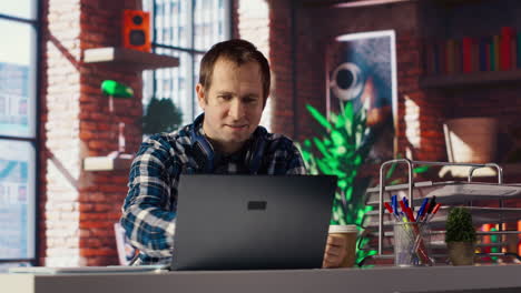 man celebrating after receiving good news, looking at notebook