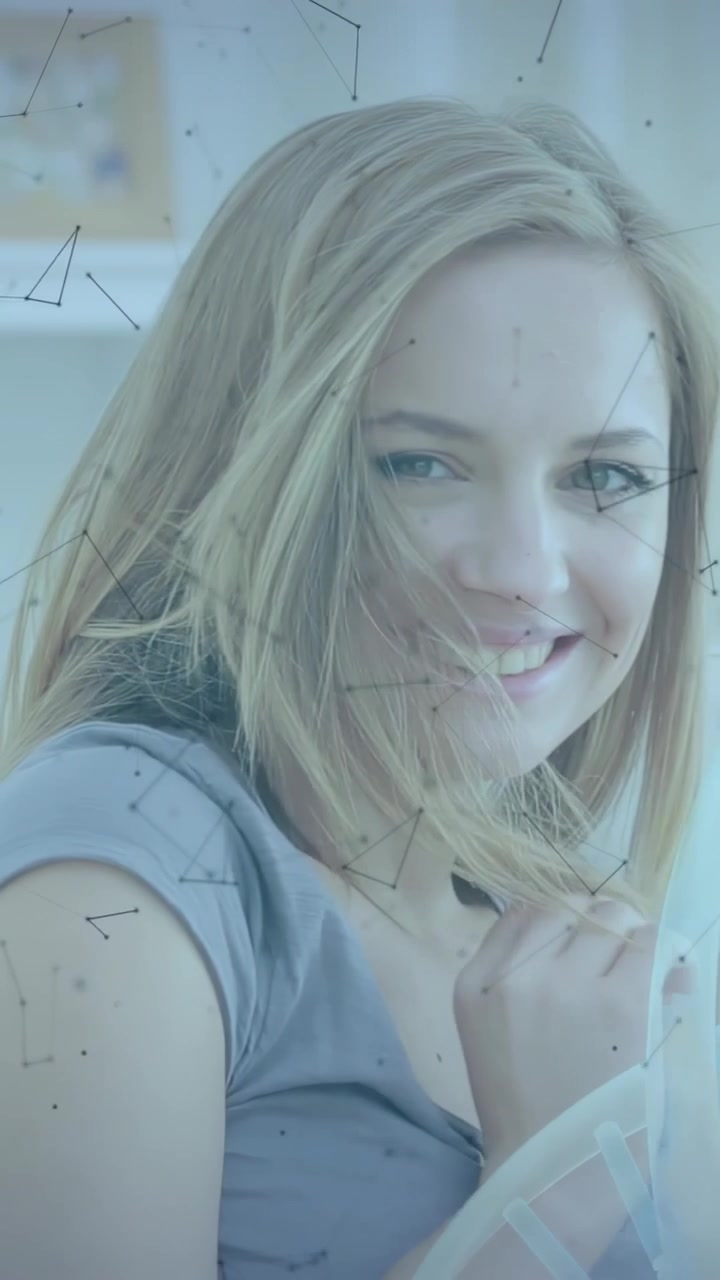 Vertical video: Reclining woman in gray top touching hair, smiling at camera on couch, ring overlay