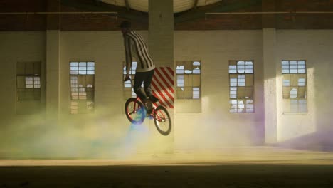 bmx riders in an empty warehouse using smoke grenade