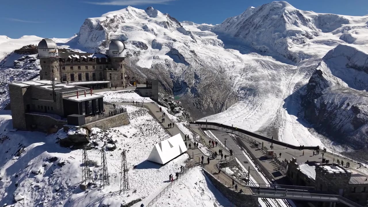 Sorvolo aereo sull'osservatorio del Gornergrat a Zermatt, Svizzera, con una vista che rivela il ghiacciaio del Gorner in una giornata autunnale innevata nelle Alpi svizzere.