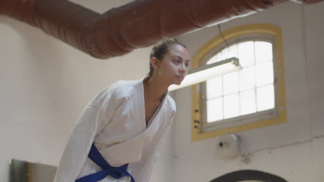 tiro deslizante de una niña inclinándose antes de comenzar el entrenamiento de karate