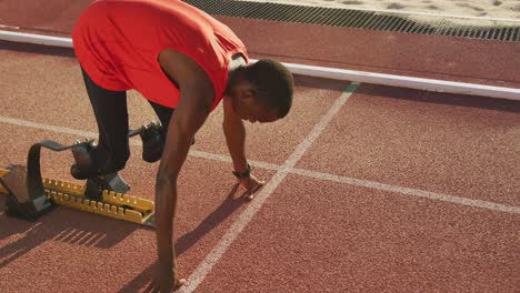 disabled mixed race man with prosthetic legs starting a race