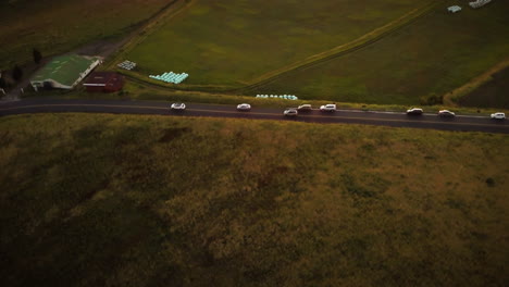 cinematic aerial view of cars driving on a road in the rural countryside