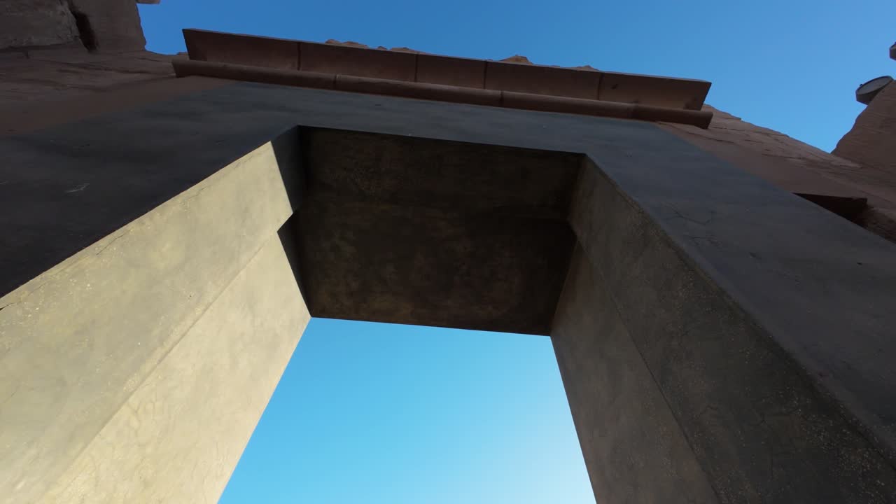 Ancient stone gate at Karnak Temple viewed from below in warm afternoon light