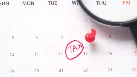 tax reminder on calendar with magnifying glass