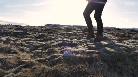 young male traveler walking in iceland lava field covered in moss