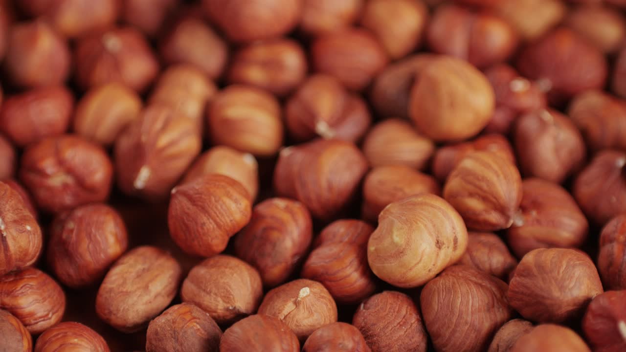 Peeled hazelnut on red plate close-up macro. Hazelnuts without shell. Product rich in minerals and vitamins. Healthy snacks. High quality 4k footage