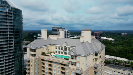 Aerial-view-of-high-rise-apartment-building-or-hotel-with-luxurious-penthouse-with-large-swimming-pool