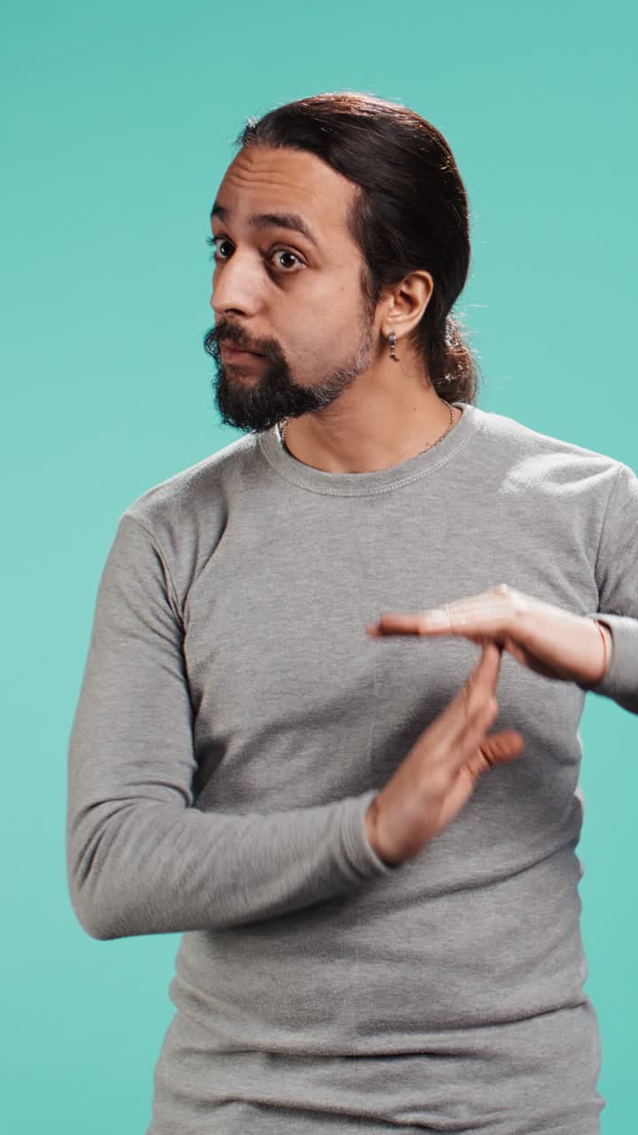 Vertical video Portrait of assertive man asking for timeout, doing hand gestures