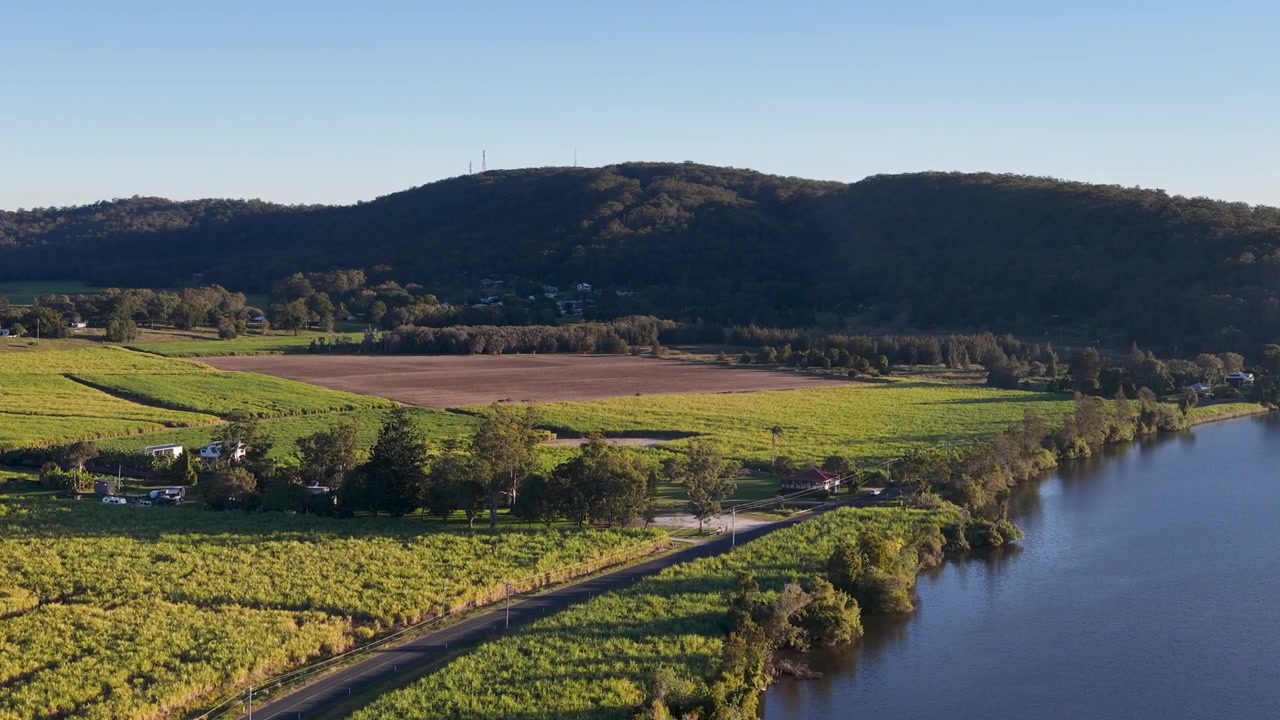 Imagem aérea de drone em ângulo elevado de fazendas rurais de cana-de-açúcar e margem de rio em Maclean, Austrália