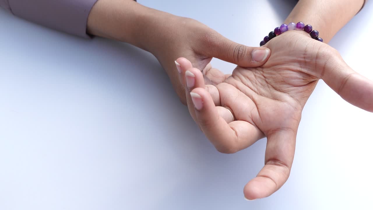 manos de mujer con pulsera púrpura