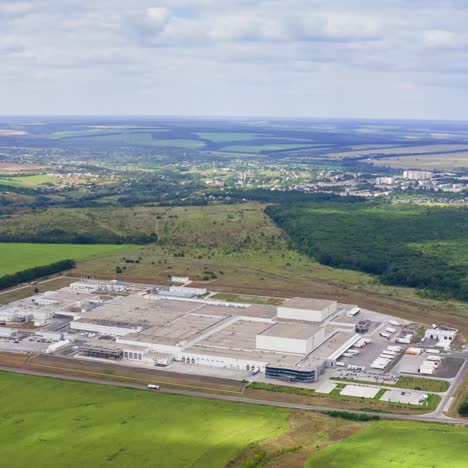 Panoramic view of a factory in nature. Large industrial zone on green fields. Manufacturing in the countryside. Aerial view