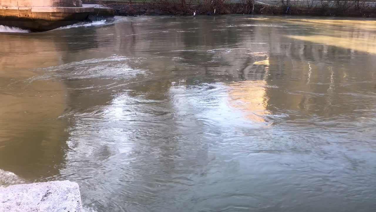 화창한 날 빠르게 흐르는 강물에 도시 스카이라인 반영