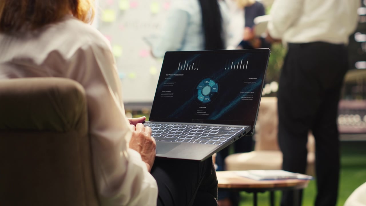 Business Professional Analyzing Data Charts on Laptop in Office