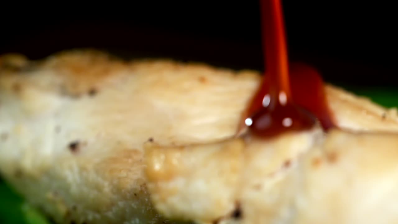 A piece of chicken meat is poured with sauce