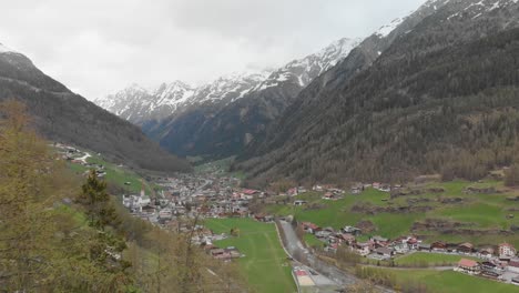 drone-shot-passing-in-the-middle-of-a-Gondola-Lift-revealing-a-small-town-in-the-austrian-alps---Sölden,-Austria