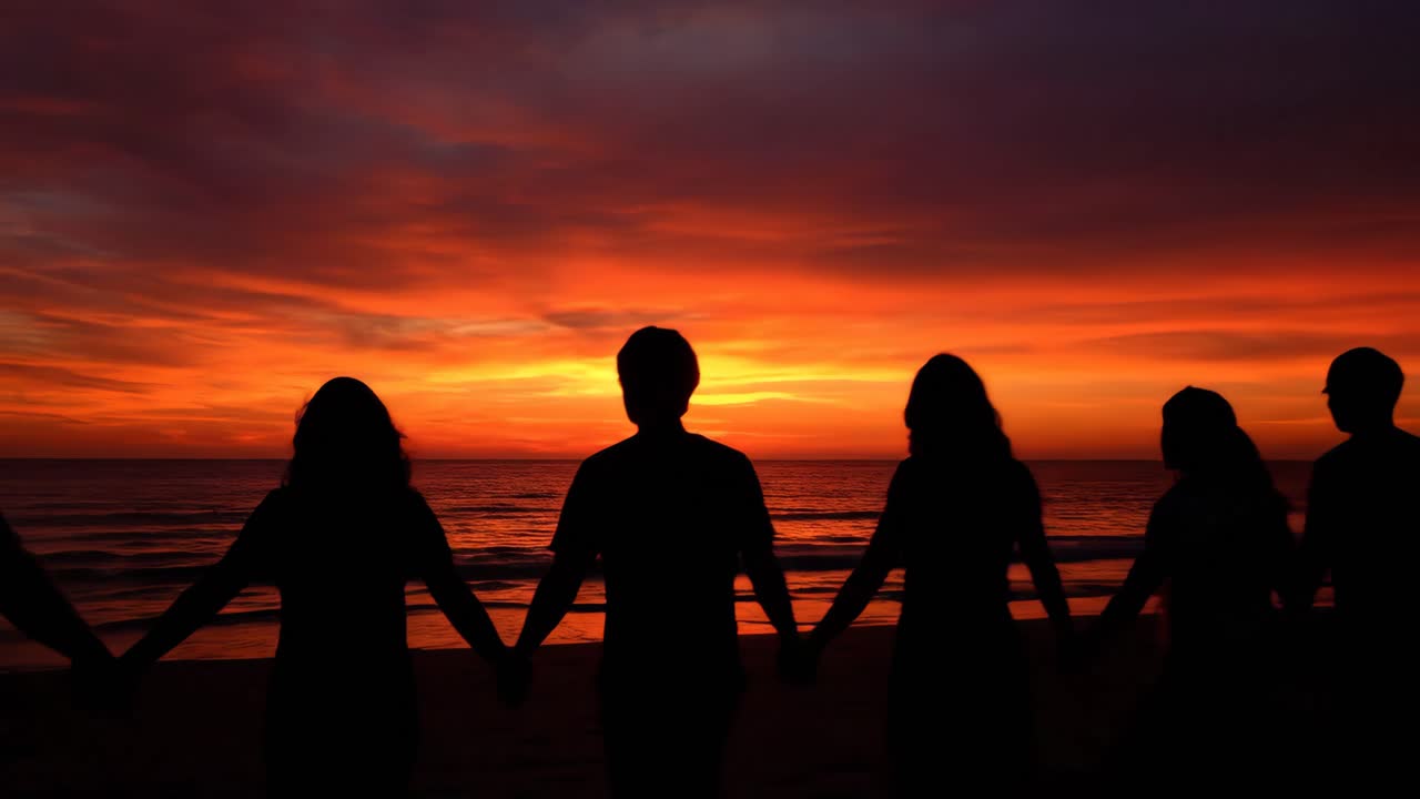 People Holding Hands on the Beach at Sunset