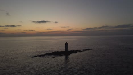 Toma-Aérea-Del-Creador-Cinematográfico-Del-Faro-Solitario-En-Medio-Del-Mar,-Atardecer