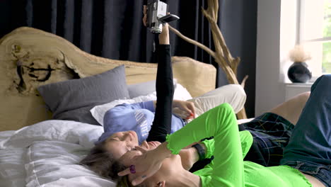 three young woman recording with video camera on a bed