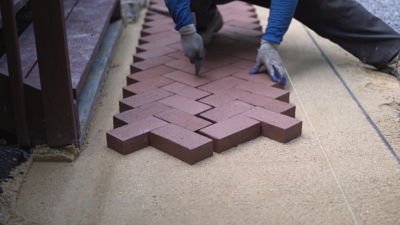 Laying brick pavers in a herringbone pattern