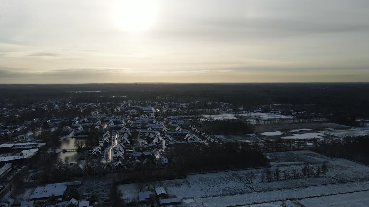 해가 지는 동안 눈으로 인 마을의 아름다운 공중 전망