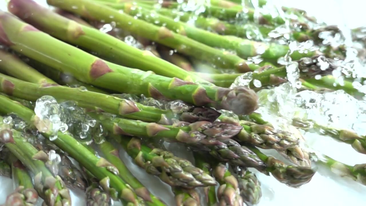 Asparagi verdi freschi. Schizzi d'acqua. Al rallentatore