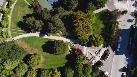 4-4-Modern-futuristic-circlular-shaped-park-birds-eye-view-aerial-rise-over-empty-dry-water-fountain-pool-across-restricted-childrens-park-during-COVID-19-pandemic-social-distancing-city-bus-hub-paths