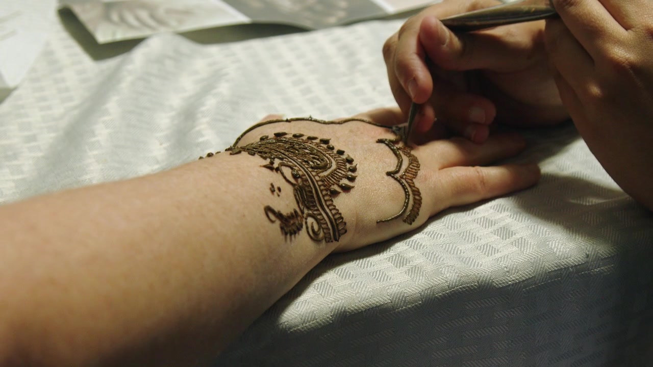 Disegno di tempio merlato realizzato con henné sul dorso della mano, mehndi.