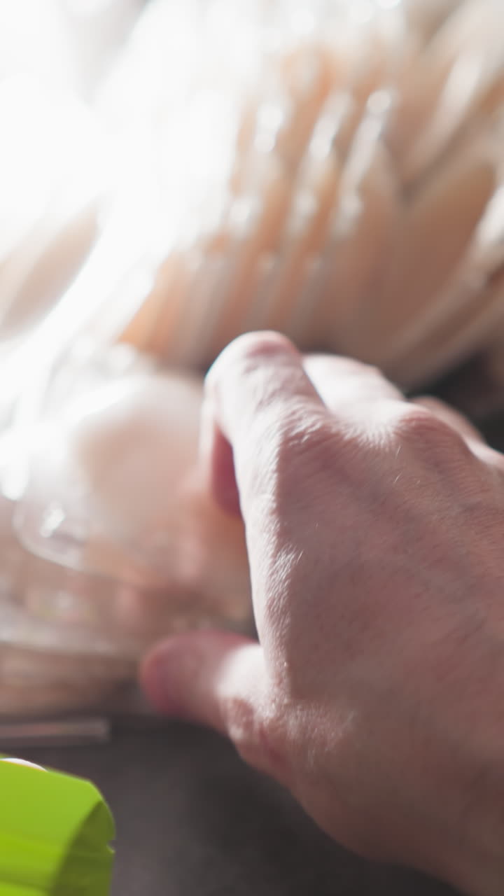 한 사람이 테이블에서 꼭지 파티를 선택하고 시장에서 판매하기 위해 지프 가방에 포장하는 pov