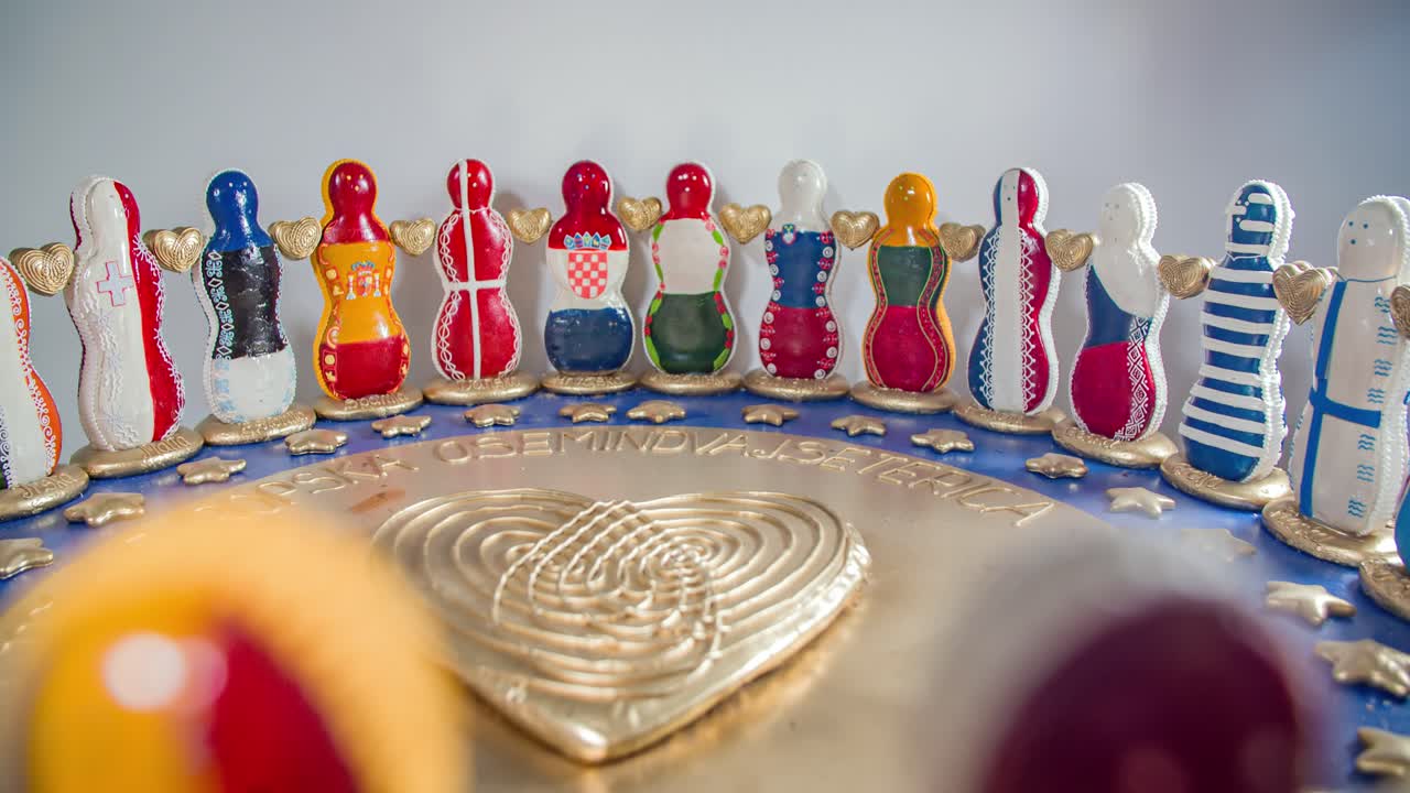 View Of Gingerbread Men Painted In European Flags In Big Circle Inside Shop. Follow Shot