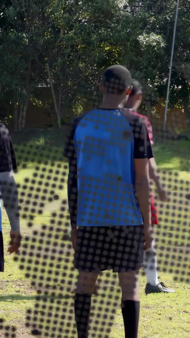 Video verticale: Giocatore in attesa su un campo da calcio, che si sposta mentre altri corrono, con un effetto puntinato che oscura.
