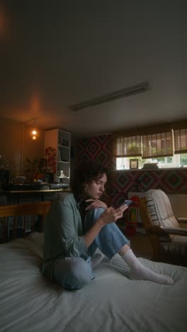 young woman using smartphone in cozy bedroom