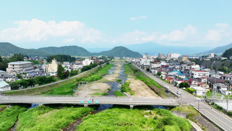 aerial tracking shot over the yomase river and the yudanaka town, summer in japan