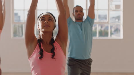yoga class beautiful mixed race woman practicing warrior pose enjoying fitness lifestyle multi ethnic group of people exercising in studio at sunrise