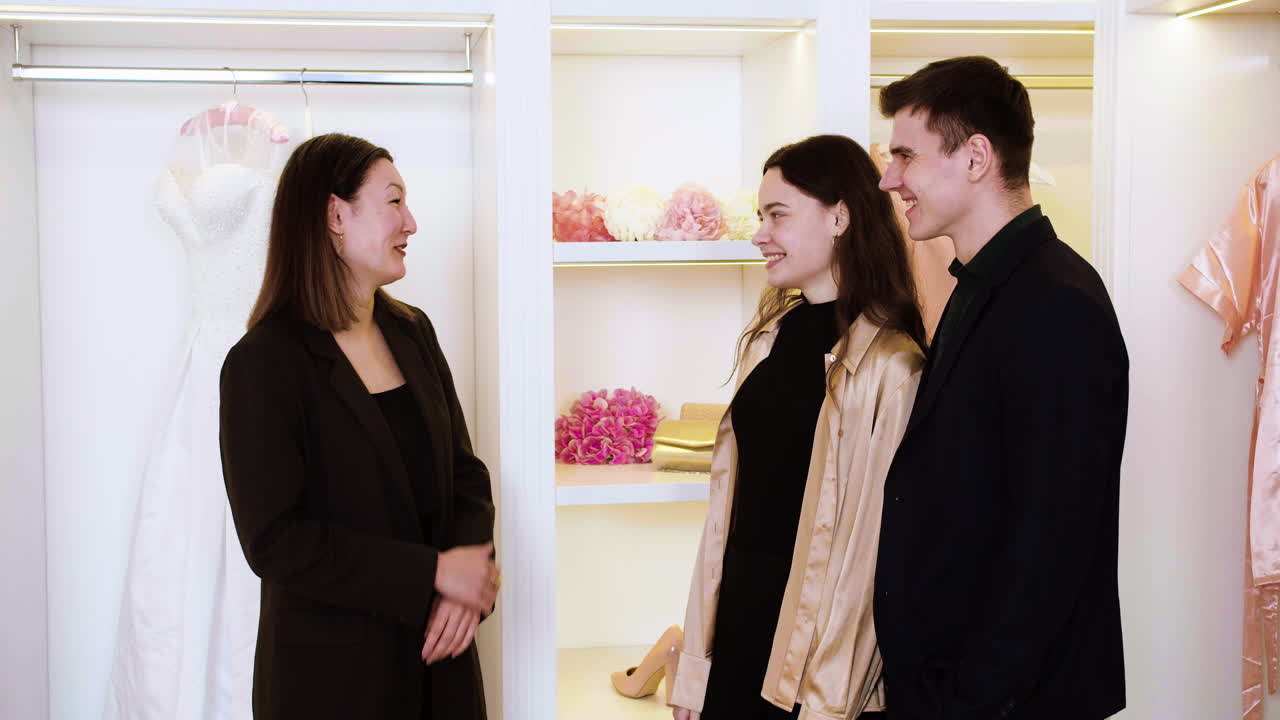 una mujer asiática hablando con una pareja.