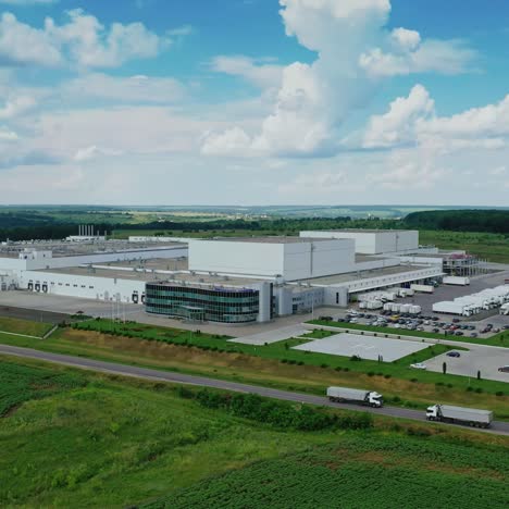 modern plant in the countryside. panoramic view on industrial area among green nature. large manufacture on field in summer.