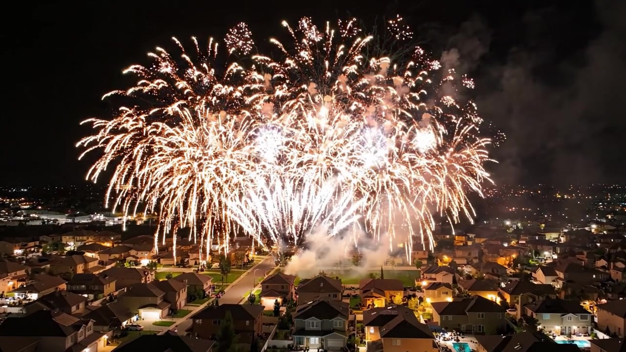 Spettacolare spettacolo pirotecnico notturno che illumina un quartiere residenziale, mettendo in mostra un vivace spettacolo di colori contro il cielo scuro.