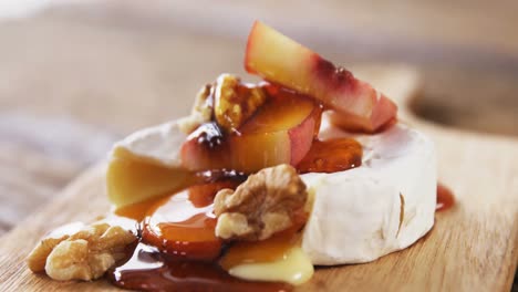 cheese topped with walnut, fruits and sauce