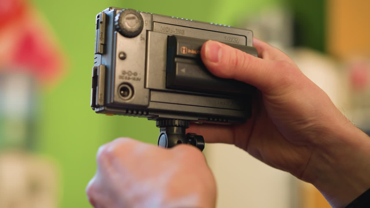 close-up shot of lighting equipment adjustment, focusing on camera rig and microphone. lighting operator preparing gear for video production. adjusting light and camera for shooting setup