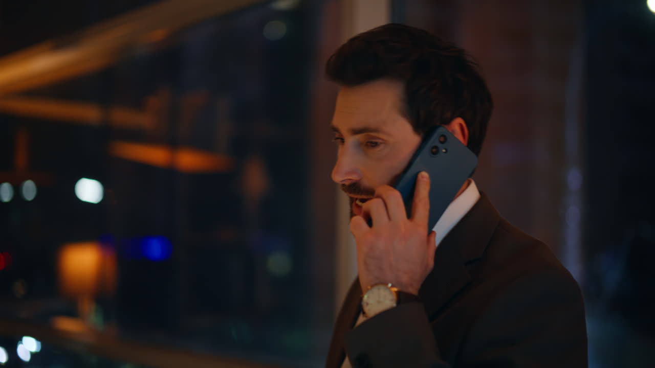 Intelligent man calling mobile phone night office closeup. Businessman talking
