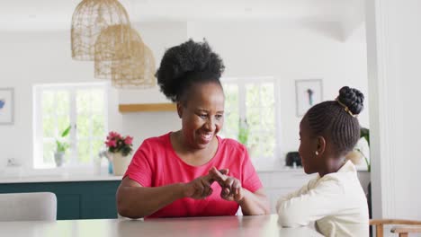 Video-of-smiling-african-american-grandmohter-using-sign-language-with-her-granddaughter,-copy-space