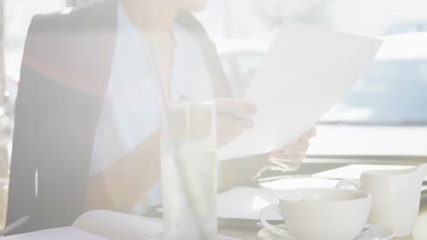 Businesswoman-doing-paper-work-in-cafe