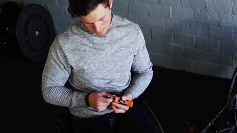 hombre discapacitado reparando una silla de ruedas en el taller 4k