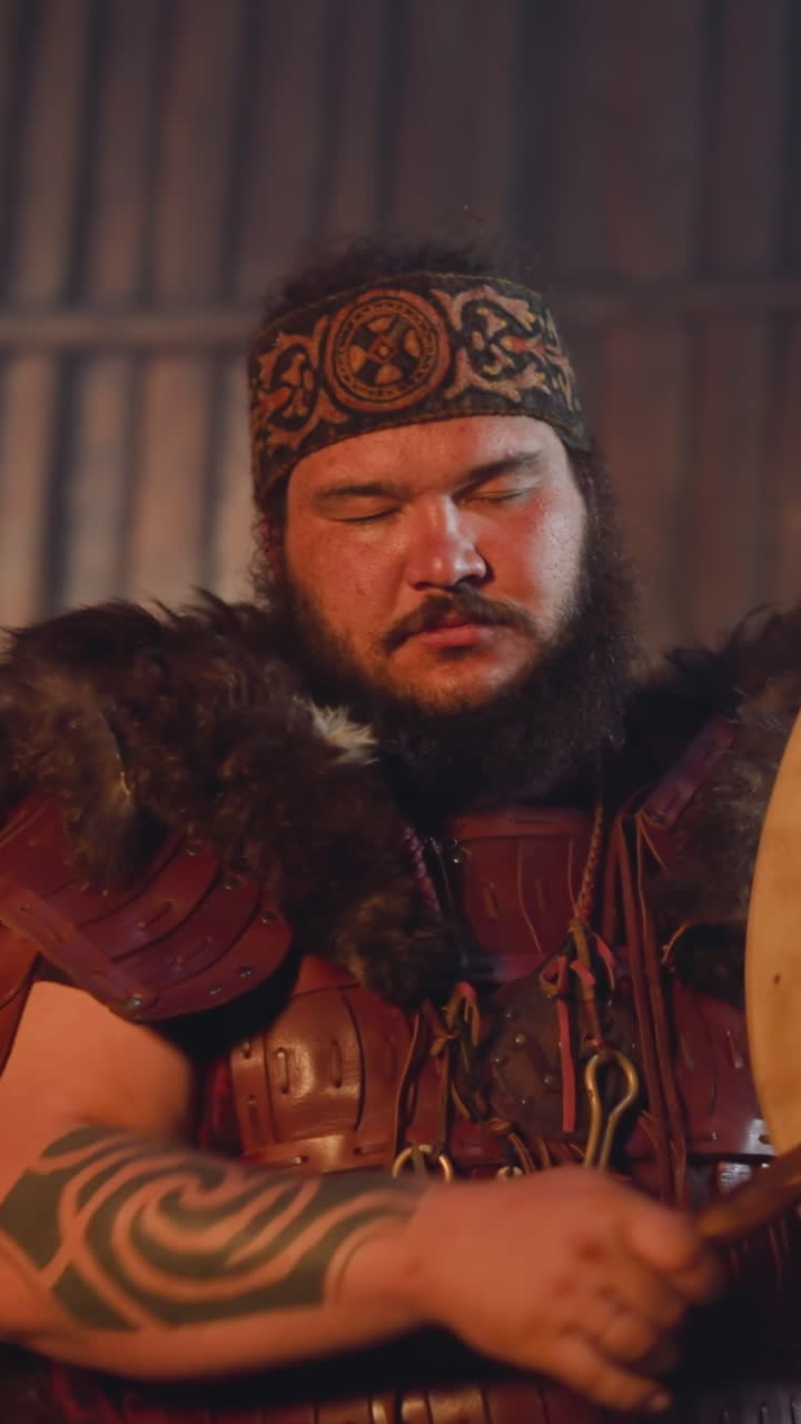 Bearded man taps shamanic tambourine trying to communicate with spirits closeup. Modern shaman at work. Altai mystical traditions and magic