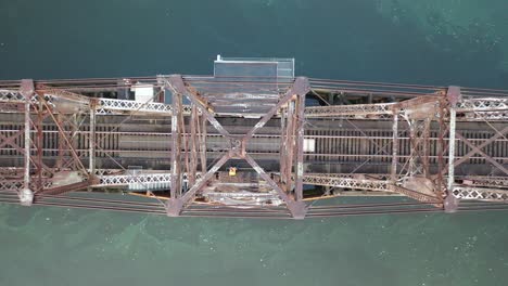 overhead view of a rusty train bridge over a river