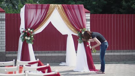 La-Joven-Decora-Con-Las-Flores-Un-Arco.